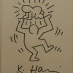 Keith Haring drawing which appears to be made with a brown marker pen, and reading ”K. Haring 86 m”.